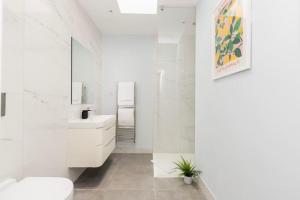 uma casa de banho branca com um lavatório e um WC em Modern House in South Kensington em Londres