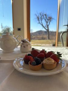 a plate of fruit on a table with a tea pot at Holiday Home Sovenigo in Puegnago