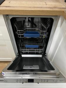 a dishwasher with its door open with dishes in it at VIP Apartmens Avalon in Lviv