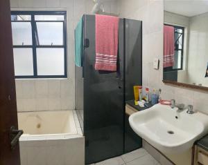 a bathroom with a shower and a sink and a tub at Flat em São Vicente in São Vicente