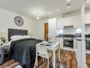 a bedroom with a bed and a table and a kitchen at Pass the Keys Chic Strand Studio in Liverpool