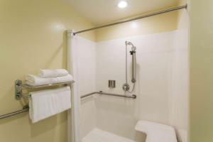 a bathroom with a shower and a toilet and towels at Days Inn & Suites by Wyndham East Flagstaff in Flagstaff +23 photos