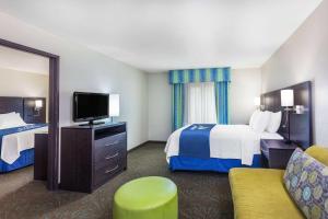 a hotel room with two beds and a television at Days Inn & Suites by Wyndham East Flagstaff in Flagstaff