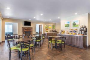 a restaurant with tables and chairs and a bar at Days Inn & Suites by Wyndham East Flagstaff in Flagstaff