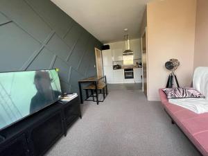 ein Wohnzimmer mit einem großen Flachbild-TV in der Unterkunft Stylish 1-Bed Apartment in Swindon in Swindon