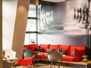un restaurante con sofá rojo y sillas en Hotel ibis Rennes Centre Gare Sud en Rennes
