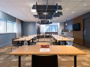 une salle de conférence avec des tables et des chaises en bois dans l'établissement Hotel ibis Rennes Centre Gare Sud, à Rennes