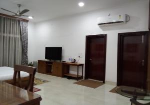 a living room with a bed and a television at Chet Residency Namsai in Namsai