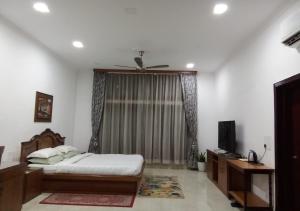 1 dormitorio con 1 cama y ventilador de techo en Chet Residency Namsai, en Namsai