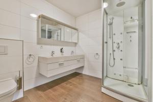 オーフェルフェーンにあるCala Bassa Beach Boutique Apartments - Sea Viewの洗面台とシャワー付きの白いバスルーム +28枚の写真