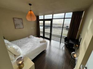 オーフェルフェーンにあるCala Bassa Beach Boutique Apartments - Sea Viewのベッドと大きな窓のある寝室