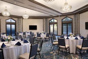 einen Konferenzraum mit Tischen, Stühlen und Kronleuchtern in der Unterkunft DoubleTree Suites by Hilton Orlando at Disney Springs in Orlando