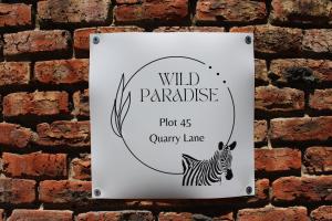 a sign with a zebra on a brick wall at Wild Paradise Cottages in Lorraine