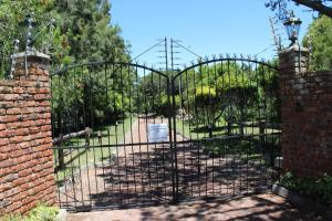 an entrance to a garden with an iron gate at Wild Paradise Cottages in Lorraine