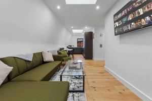 a living room with a green couch and a table at Sleep6 near Tower Bridge Central london LR4 in London