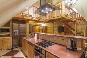 a kitchen with a wooden counter and a spiral staircase at Apartamenty Bukowina in Bukowina Tatrzańska