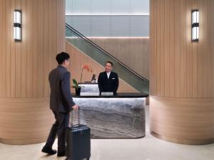 a man in a suit with a suitcase in a lobby at Grand Mercure Singapore Roxy in Singapore