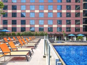 uma piscina de hotel com cadeiras e um edifício em Grand Mercure Singapore Roxy em Singapura