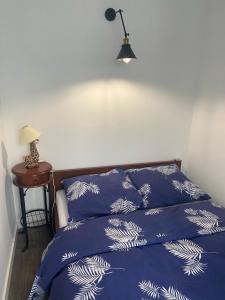 a bedroom with a bed with blue sheets and a lamp at Klonowa 65 z garażem podziemnym in Kielce