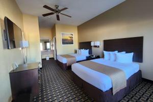 a hotel room with two beds and a ceiling fan at Days Inn by Wyndham Baytown East in Baytown