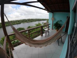 a hammock on the balcony of a house overlooking a river at Pousada Vida Nova Barreirinhas MA in Barreirinhas