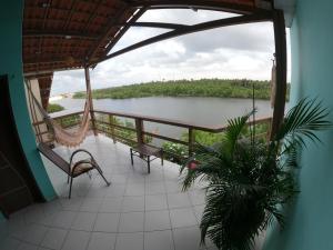a balcony with chairs and a view of a river at Pousada Vida Nova Barreirinhas MA in Barreirinhas
