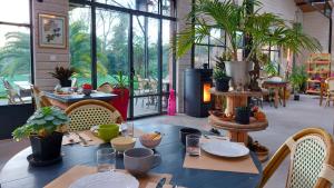 a dining room with a table with plants on it at Laiterie de Tocqueville B&B in Tocqueville