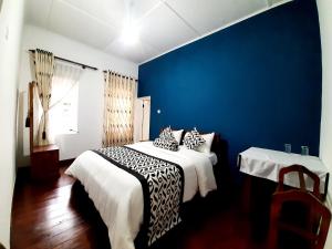1 dormitorio con 1 cama con pared azul en Sapu's Mountain breeze Nuwara Eliya, en Nuwara Eliya