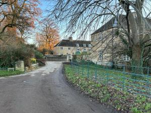 a dirt road in front of a large building at Cottage Nestled In Countryside in Kirtlington