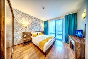 een hotelkamer met een bed en een televisie bij Oak Residence Hotel & Relax in Smolyan