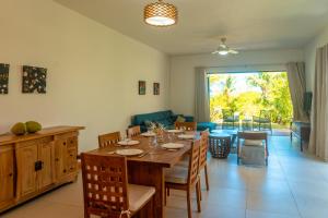 a dining room and living room with a table and chairs at Stunning Belle Mare Beachfront luxury Apartment in Belle Mare