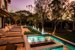 a backyard with a swimming pool and a fountain at Chateau Laghetto Collection in Gramado