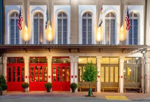 a building with red doors and american flags at The Eliza Jane, in The Unbound Collection by Hyatt in New Orleans