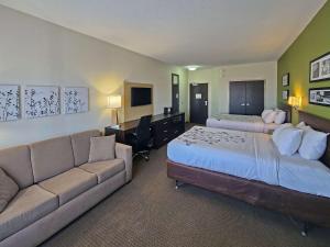 ColumbiaにあるSleep Inn & Suites Columbiaのベッド2台とソファが備わるホテルルームです。