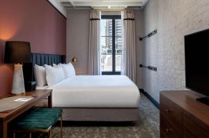 um quarto de hotel com uma cama grande e uma televisão em The Eliza Jane, in The Unbound Collection by Hyatt em Nova Orleans
