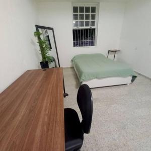 Zimmer mit einem Schreibtisch, einem Bett und einem Tisch in der Unterkunft Raridade! Mansão espetacular em Botafogo. in Rio de Janeiro