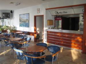 a restaurant with wooden tables and blue chairs at APARTMENTS ON THE BEACH IN BAY MALA LUKA in Omiš