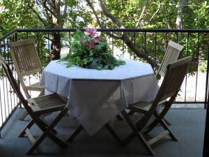 a table with a white table cloth and two chairs at APARTMENTS ON THE BEACH IN BAY MALA LUKA in Omiš