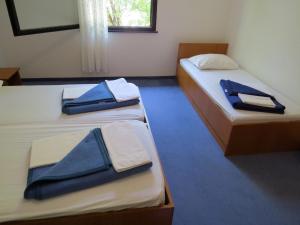 two beds in a room with blue towels on them at APARTMENTS ON THE BEACH IN BAY MALA LUKA in Omiš