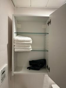 een handdoekenrek met handdoeken en een tas in de badkamer bij Style Lab北千住 in Tokyo