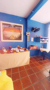Pokój z niebieskimi ścianami i stołem w pokoju w obiekcie PARAÍSO TOM DO MAR 2 w mieście Arraial do Cabo