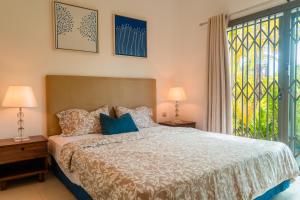 a bedroom with a bed and a large window at Stunning Belle Mare Beachfront luxury Apartment in Belle Mare