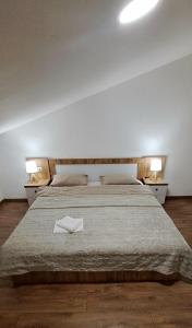 a bedroom with a large bed with a white towel on it at Matt & Sarah’s Cozy Family Duplex in Gudauri