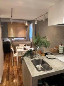 een keuken met een wastafel en een bed in een kamer bij Style Lab北千住 in Tokyo