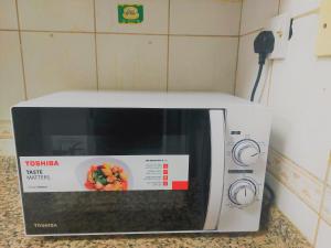 a microwave with a bowl of food on top of it at Furnished bedroom near Abu Dhabi Corniche in Abu Dhabi