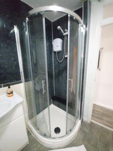 a shower with a glass door in a bathroom at Double King Bed Central Apartment by Property Promise in Cardiff