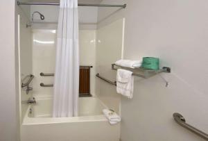 ein Bad mit einer Badewanne und einer Dusche mit einem Duschvorhang in der Unterkunft Motel 6 McAlester OK - South in McAlester