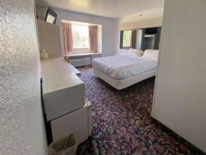 a bedroom with a white bed and a window at Motel 6 McAlester OK - South in McAlester