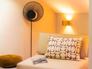 a room with a bed with a fan and a pillow at Le Saint Gervais Hotel & Spa Handwritten Collection in Saint-Gervais-les-Bains