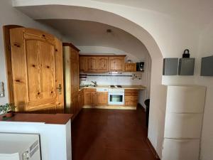 een keuken met houten kasten en een witte koelkast bij Gwuni's Farm in Geithain